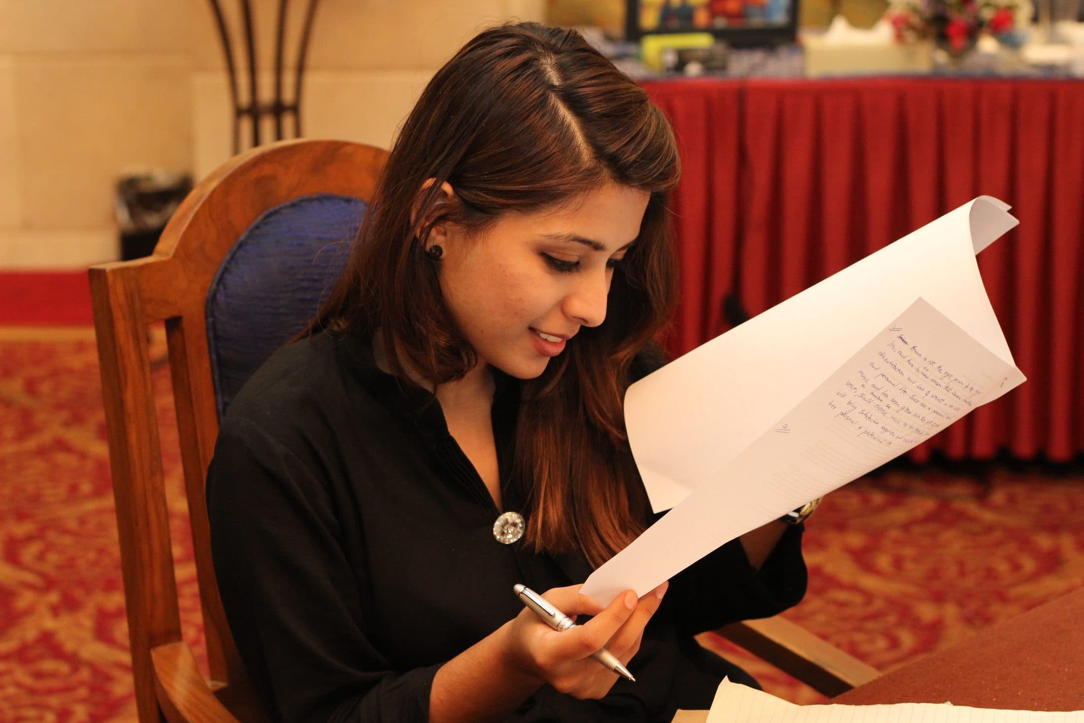 A participant reading back a handwritten page, pen still in hand