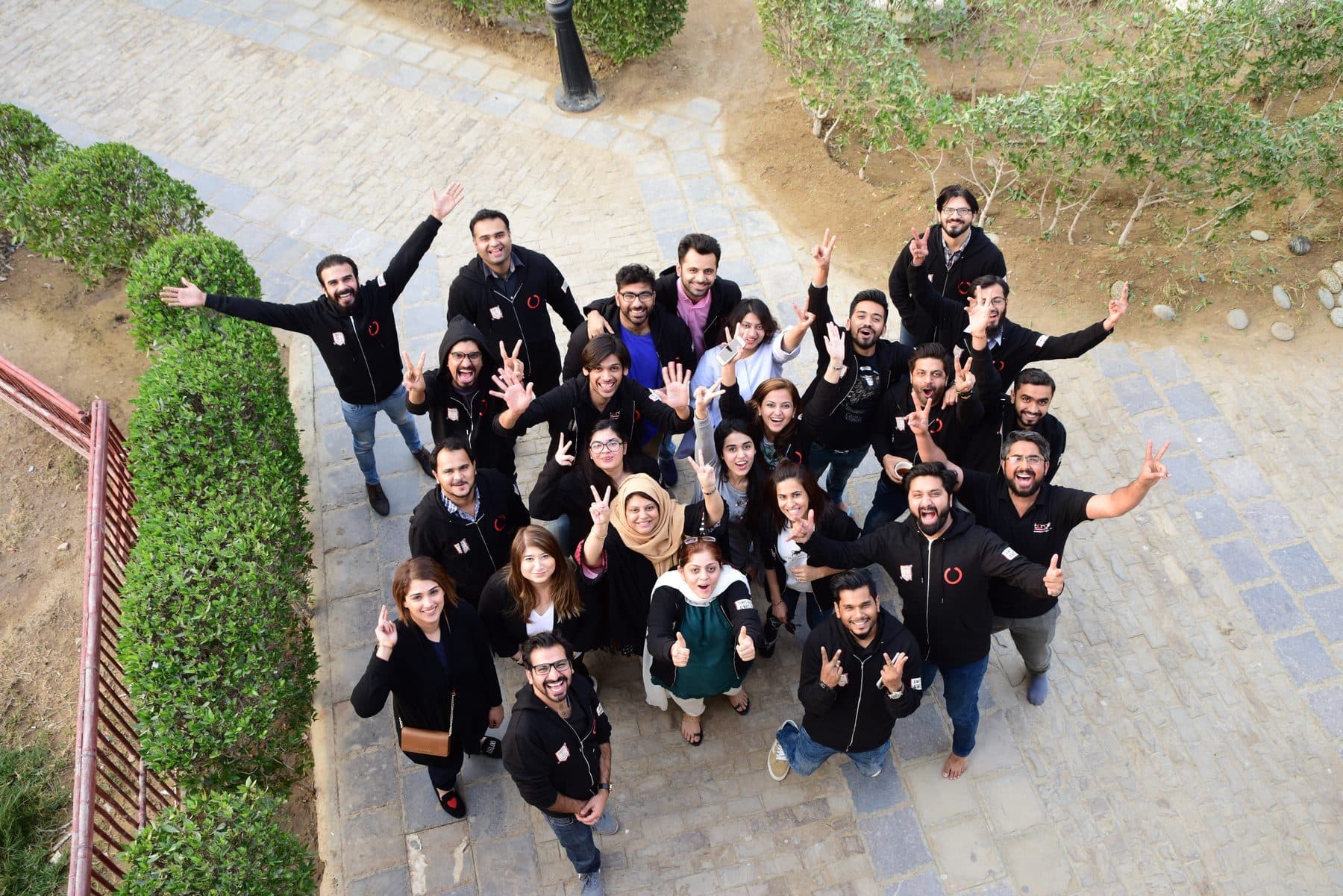 A Torque group photographed from above, arms out, mid-jump on a lawn