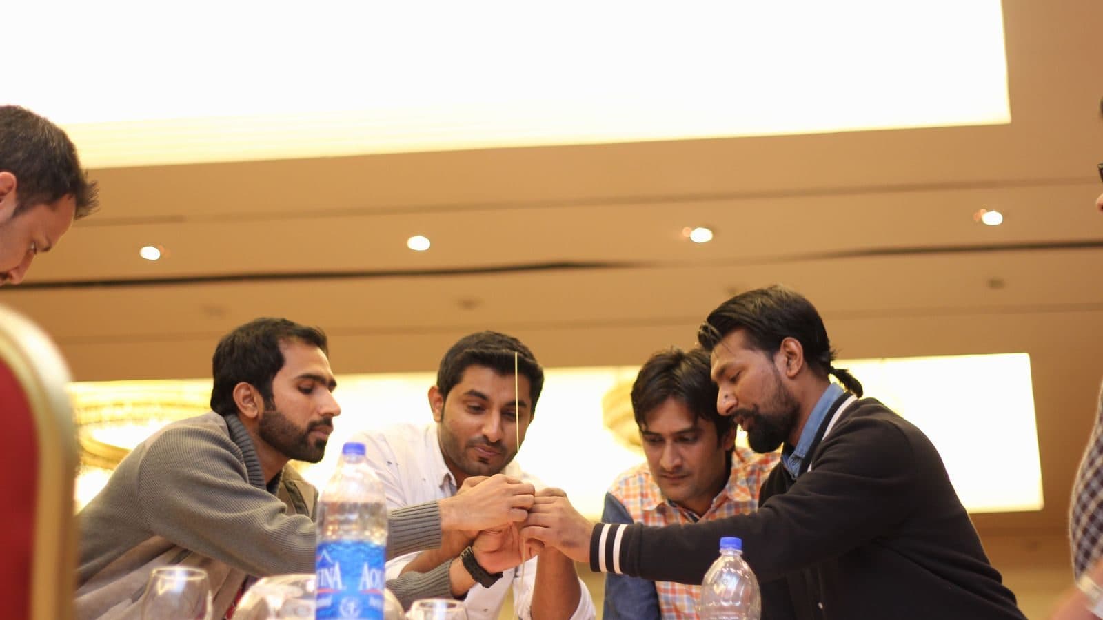 Four participants leaning into the middle of a table, deep in an argument